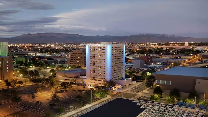 The Doubletree by Hilton Hotel Albuquerque at night with blue lights.